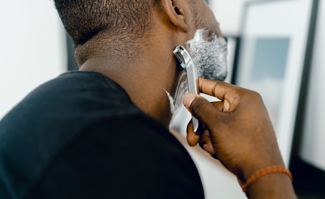 shaving soap vs cream: man using shaving cream