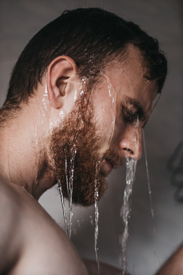 man washing beard in shower