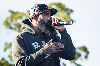Stalley rapping with his beard in a hat and sweatshirt